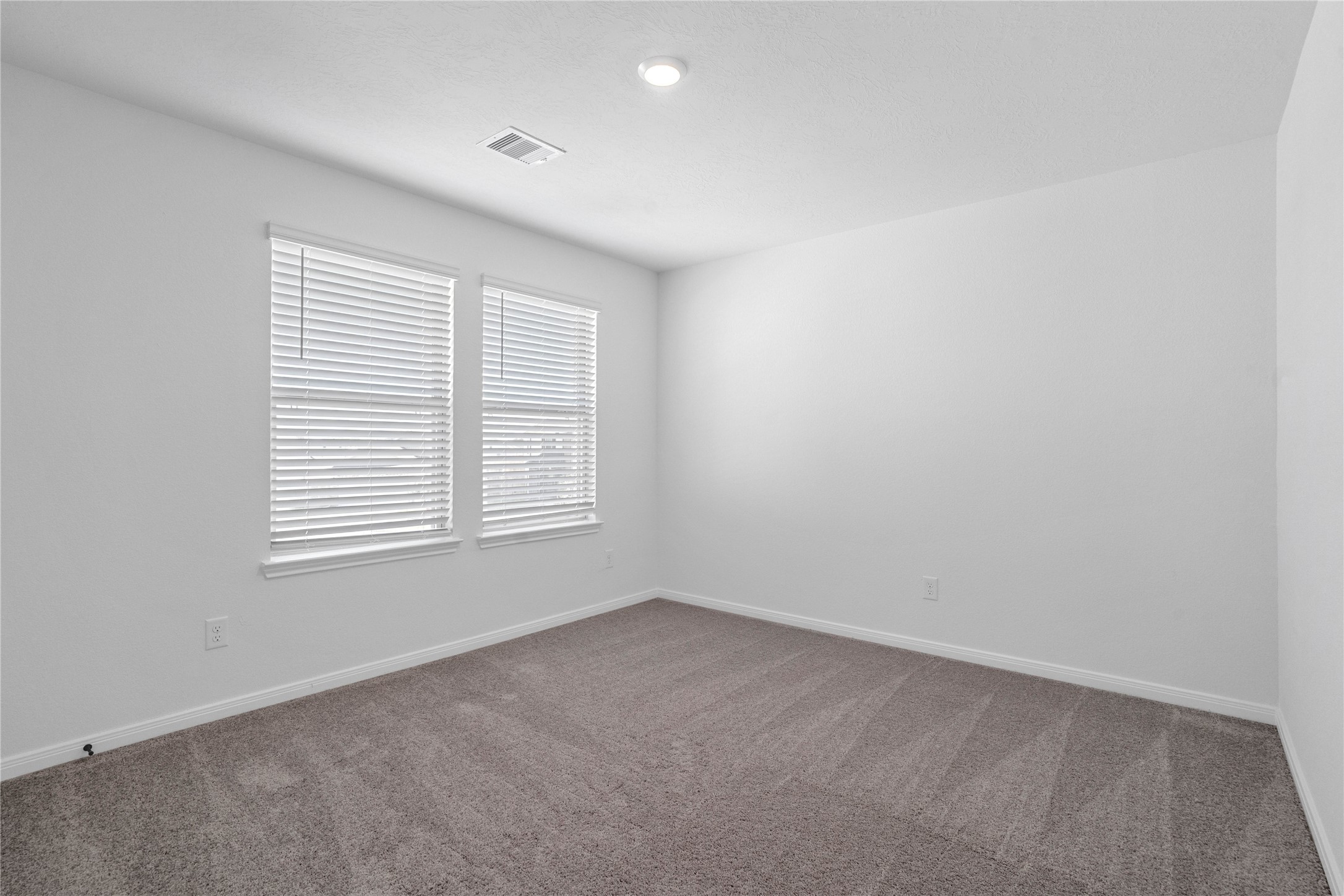 6406 Canby Court Rosharon, TX 77583 - Photo 19 of 28 This secondary bedroom offers comfort and style with plush carpeting, neutral paint tones, recessed lighting, large windows with blinds, and a walk-in closet.
