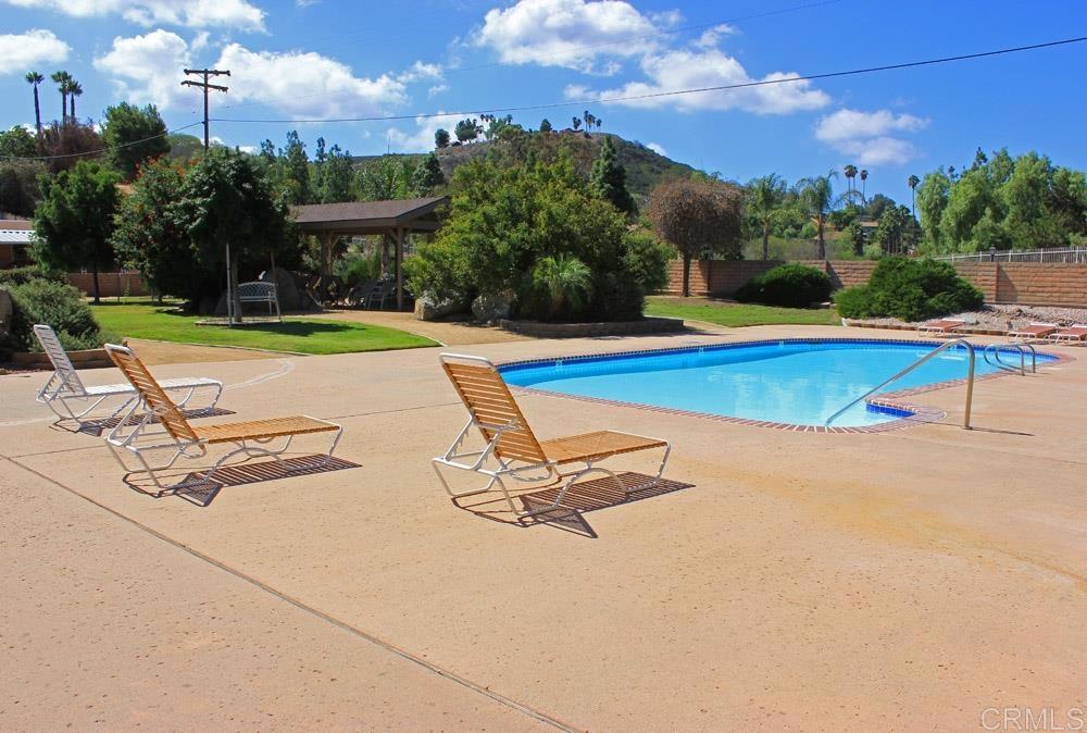 1175 La Moree Road, Unit 10 San Marcos, CA 92078 - Photo 35 of 40 a view of a swimming pool with a bench and lawn chairs