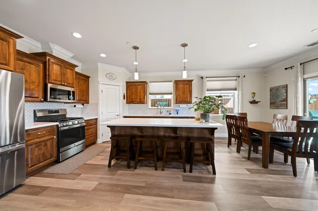 a large kitchen with cabinets table and chairs
