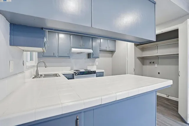 a large kitchen with kitchen island a sink stainless steel appliances and wooden floor