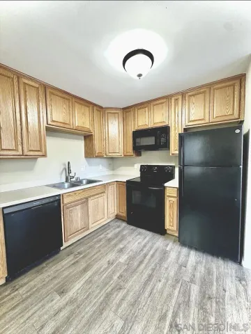 a kitchen with granite countertop a refrigerator and cabinets