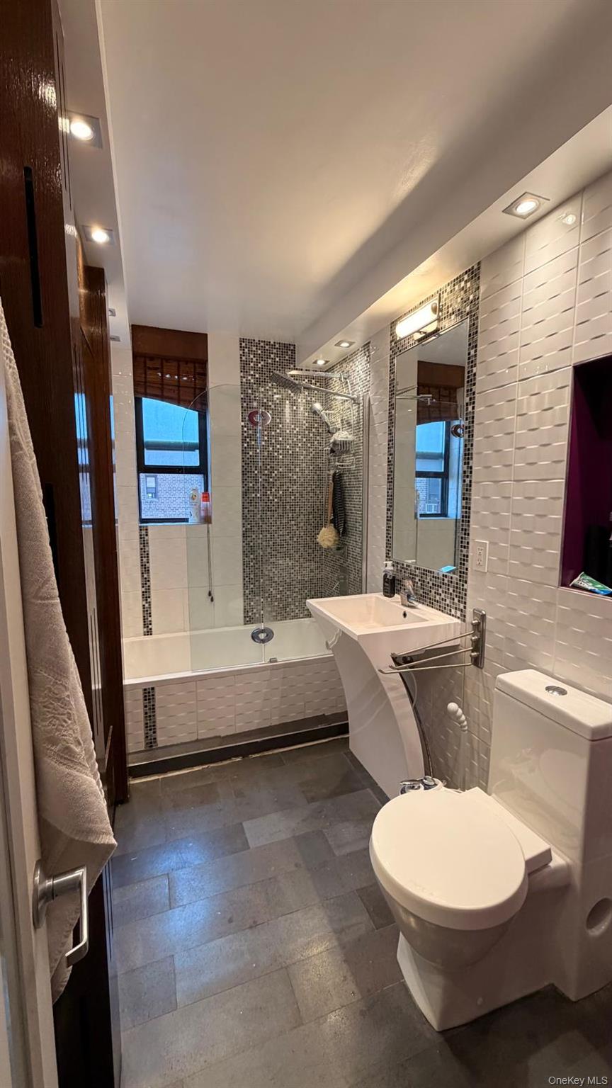 8305 98th Street, Unit 3C Queens, NY 11421 - Photo 17 of 19 a bathroom with a toilet a sink and bathtub