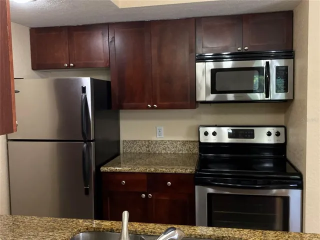 a kitchen with a refrigerator stove and microwave