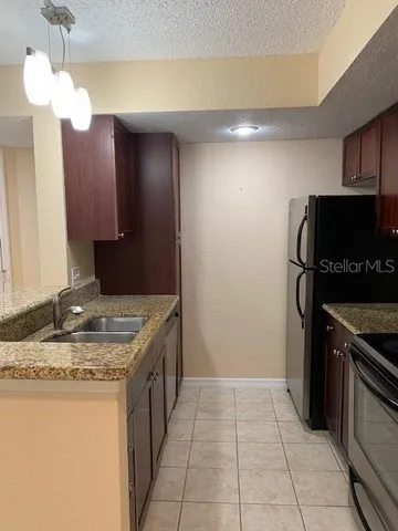 a kitchen with a stove a refrigerator and a sink