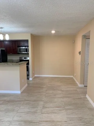 a view of kitchen with stainless steel appliances granite countertop a stove and a sink