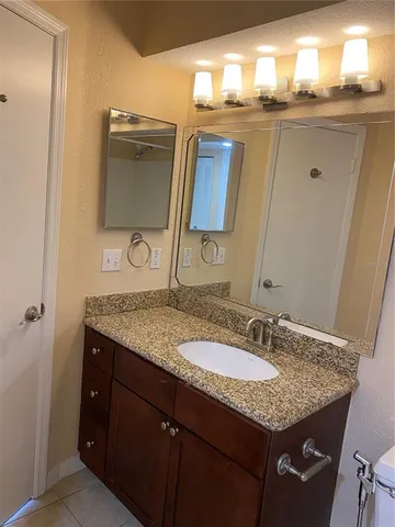 a bathroom with a granite countertop sink and a mirror