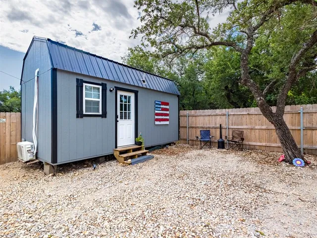 a backyard of a house with barbeque oven table and chairs