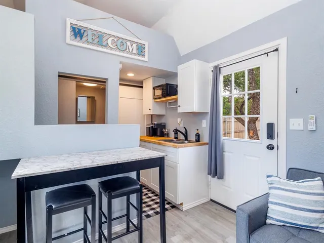 a kitchen with a table chairs refrigerator and cabinets