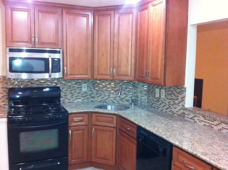 a kitchen with granite countertop wood cabinets stainless steel appliances and a sink