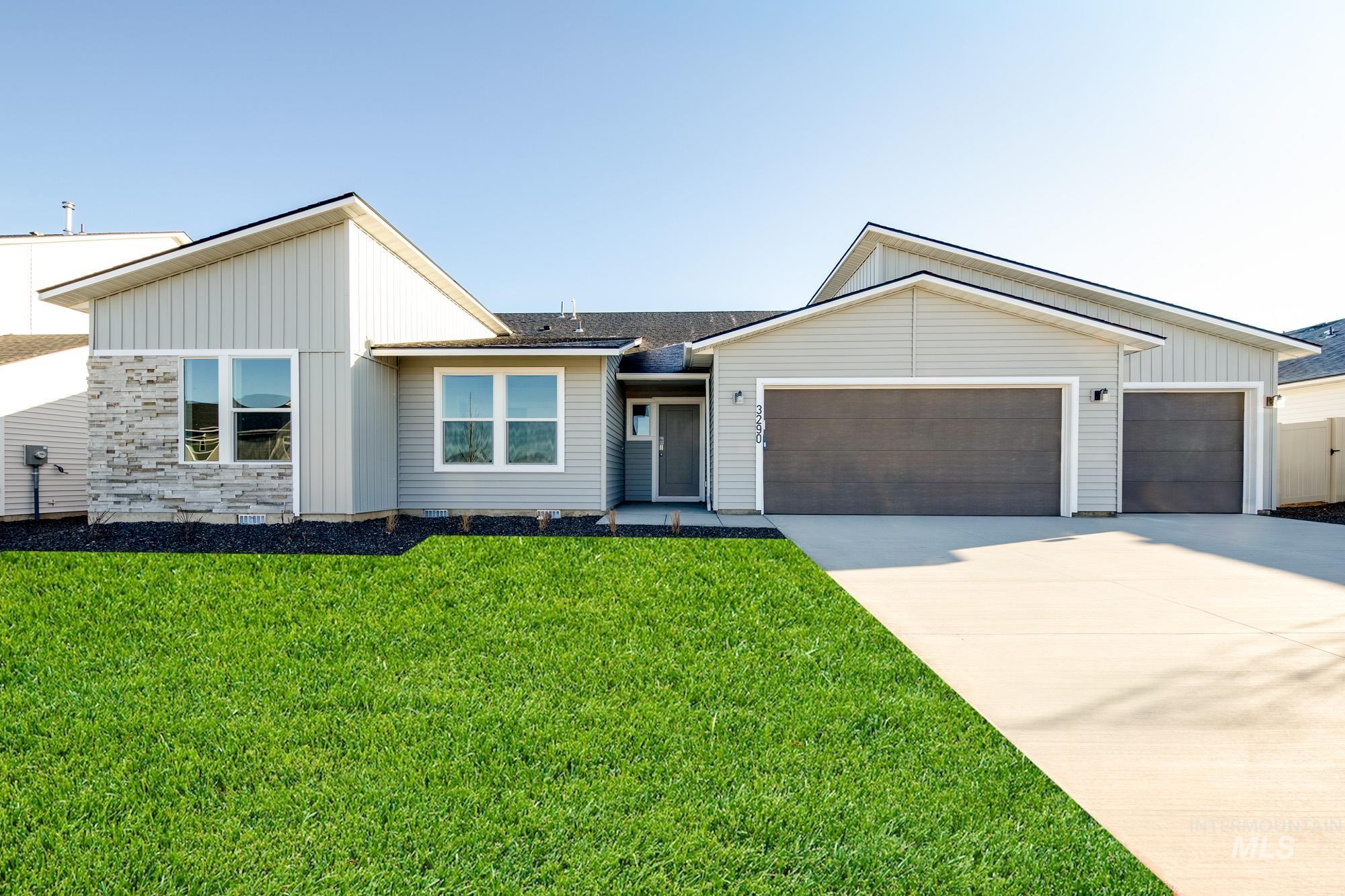View of front of property with a front lawn, board and batten siding, concrete driveway, an attached garage, and roof with shingles