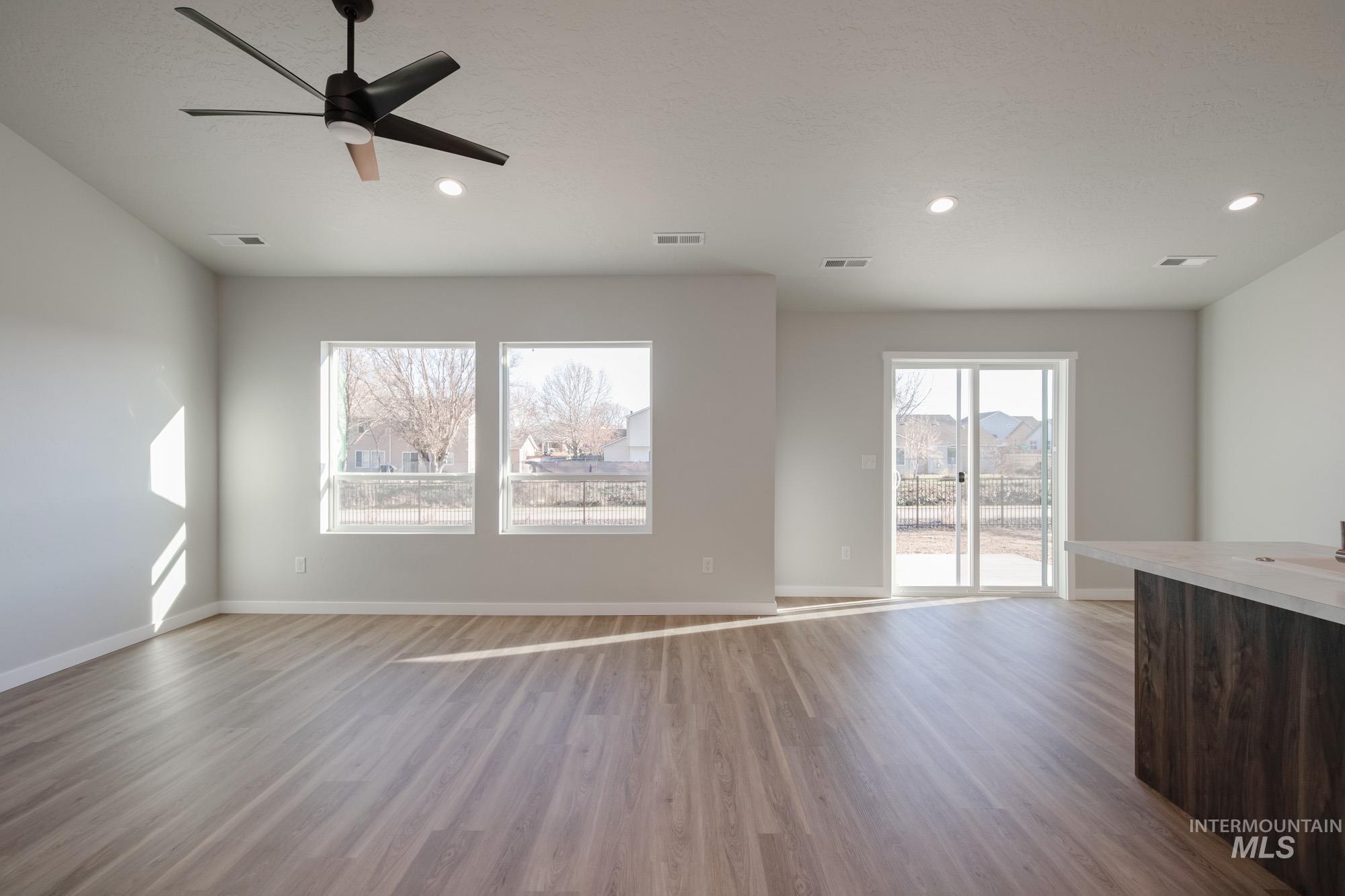3290 South Maple Rnch Way Nampa, ID 83686 - Photo 9 of 20 Unfurnished living room with light wood-style floors, ceiling fan, and recessed lighting