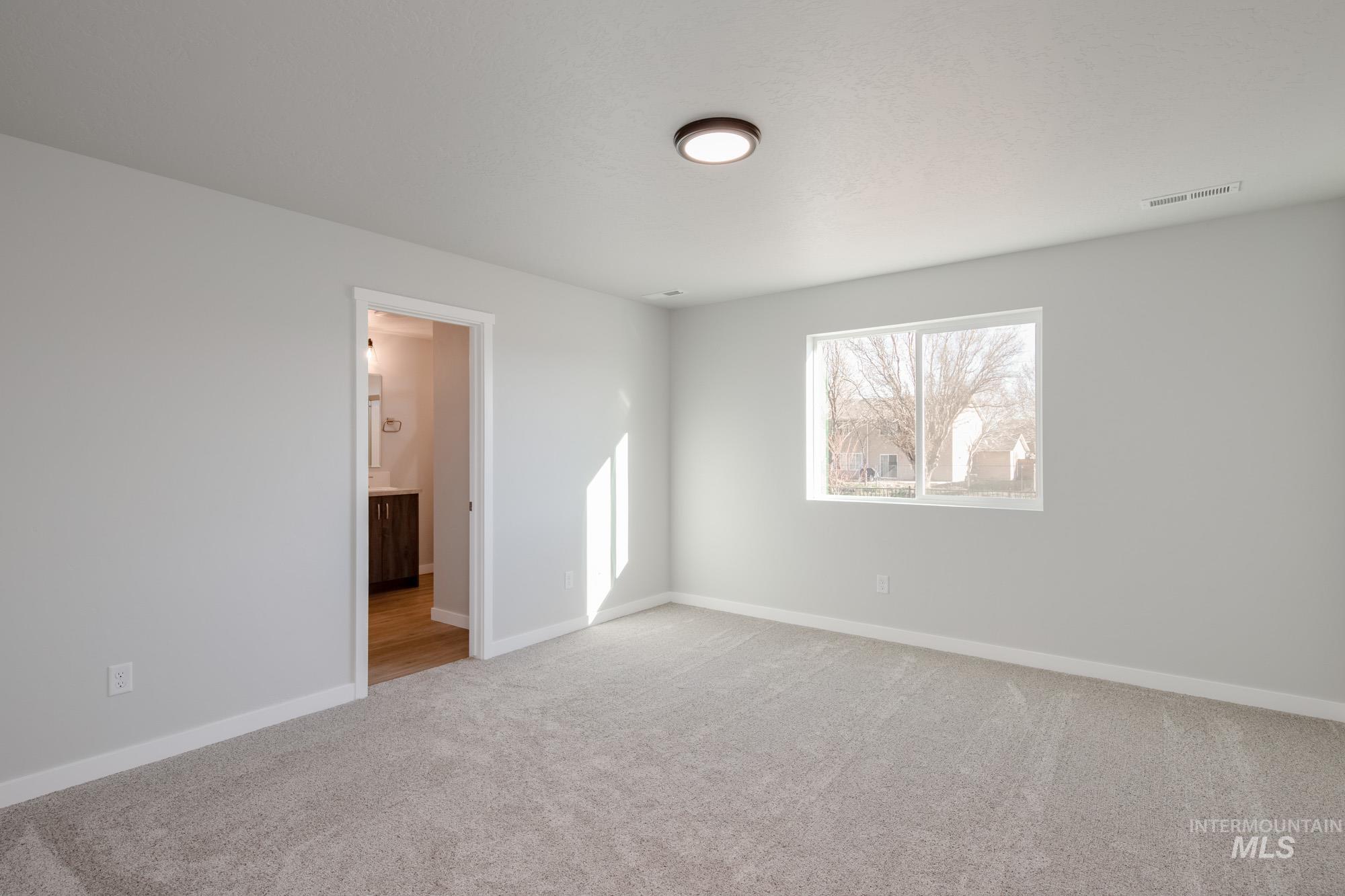 3290 South Maple Rnch Way Nampa, ID 83686 - Photo 14 of 20 Unfurnished bedroom featuring light colored carpet and connected bathroom