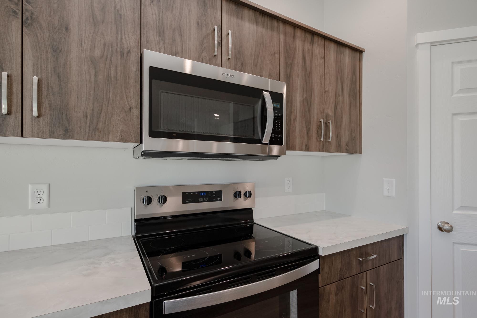 3290 South Maple Rnch Way Nampa, ID 83686 - Photo 5 of 20 Kitchen featuring stainless steel appliances, modern cabinets, light countertops, and brown cabinets