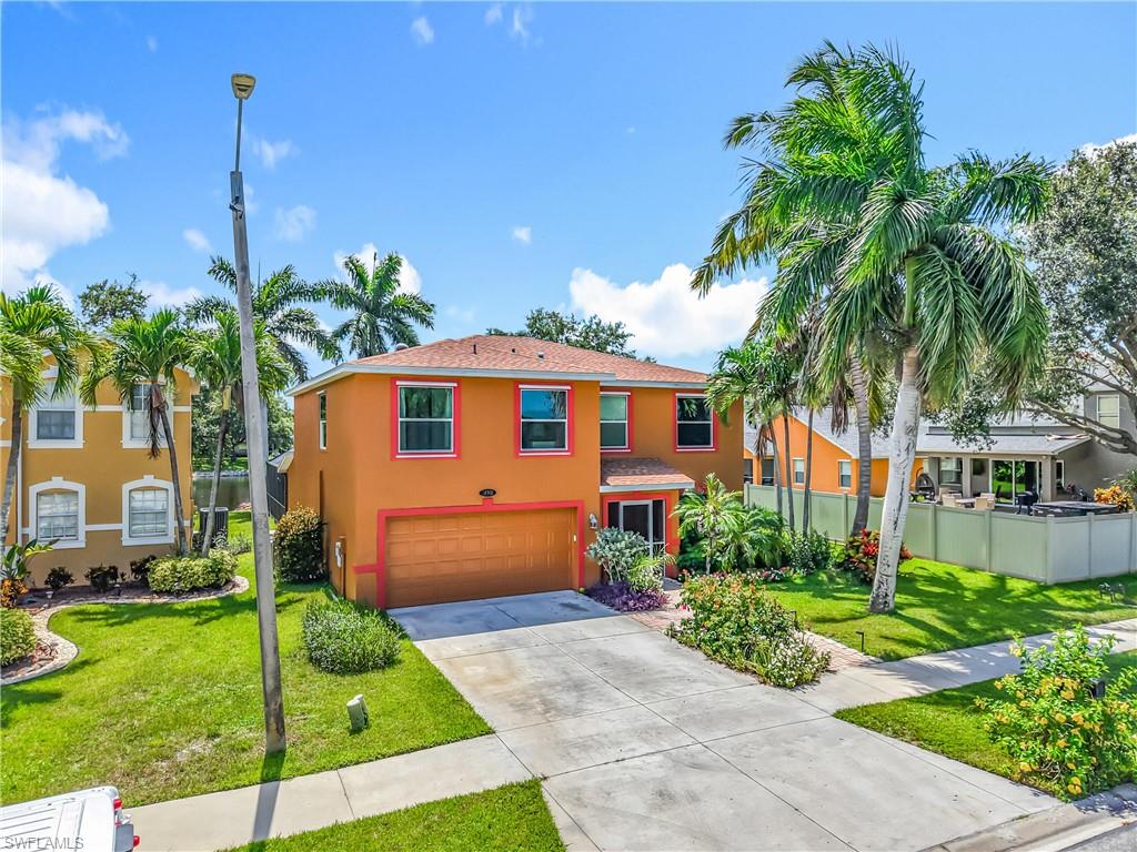 14991 Savannah Drive Naples, FL 34119 - Photo 1 of 50 a front view of a house with a yard and potted plants