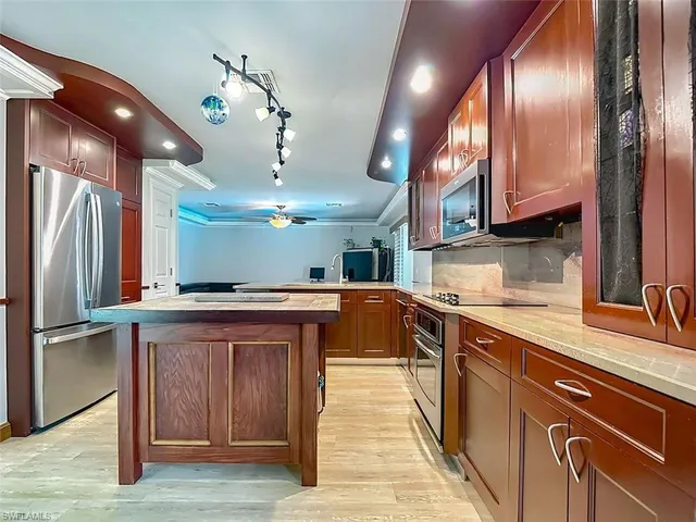 a kitchen with stainless steel appliances granite countertop a sink a stove and a refrigerator