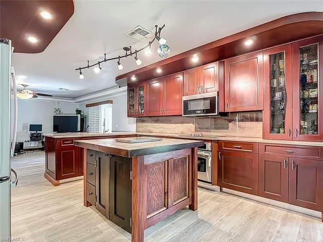 a kitchen with kitchen island granite countertop lots of counter top space and stainless steel appliances