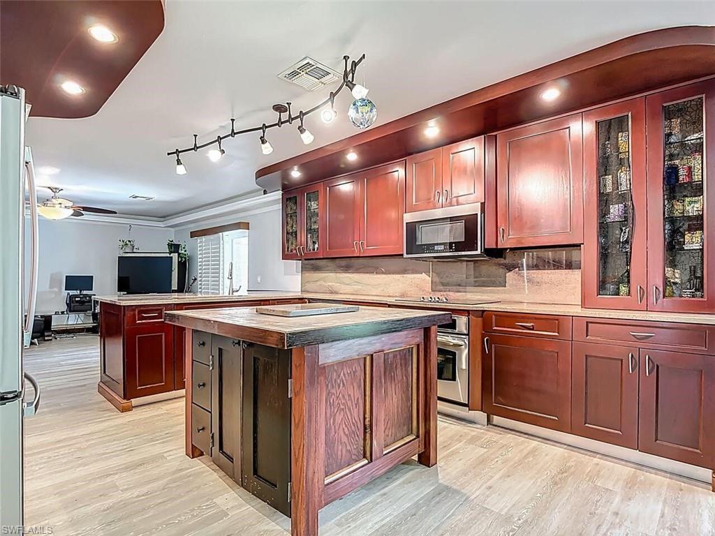 14991 Savannah Drive Naples, FL 34119 - Photo 22 of 50 a kitchen with kitchen island granite countertop lots of counter top space and stainless steel appliances