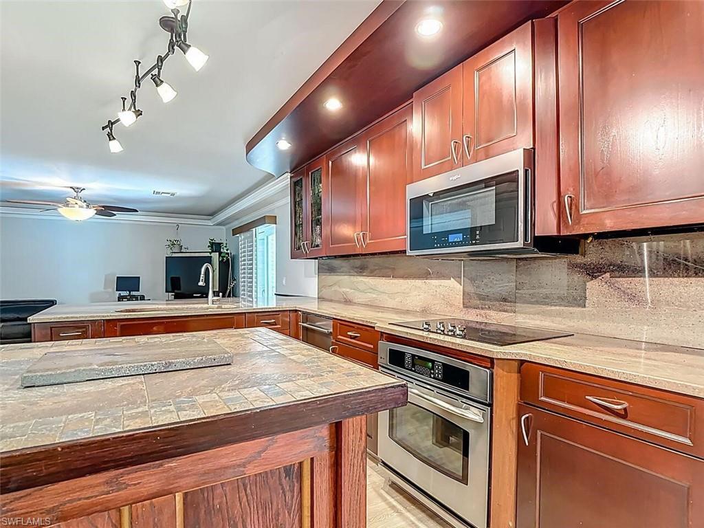 14991 Savannah Drive Naples, FL 34119 - Photo 25 of 50 a kitchen with stainless steel appliances granite countertop a sink and cabinets