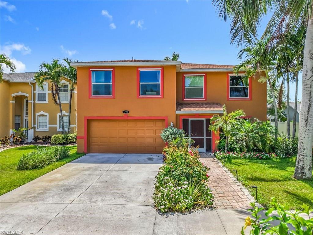 14991 Savannah Drive Naples, FL 34119 - Photo 3 of 50 a front view of a house with a yard and potted plants