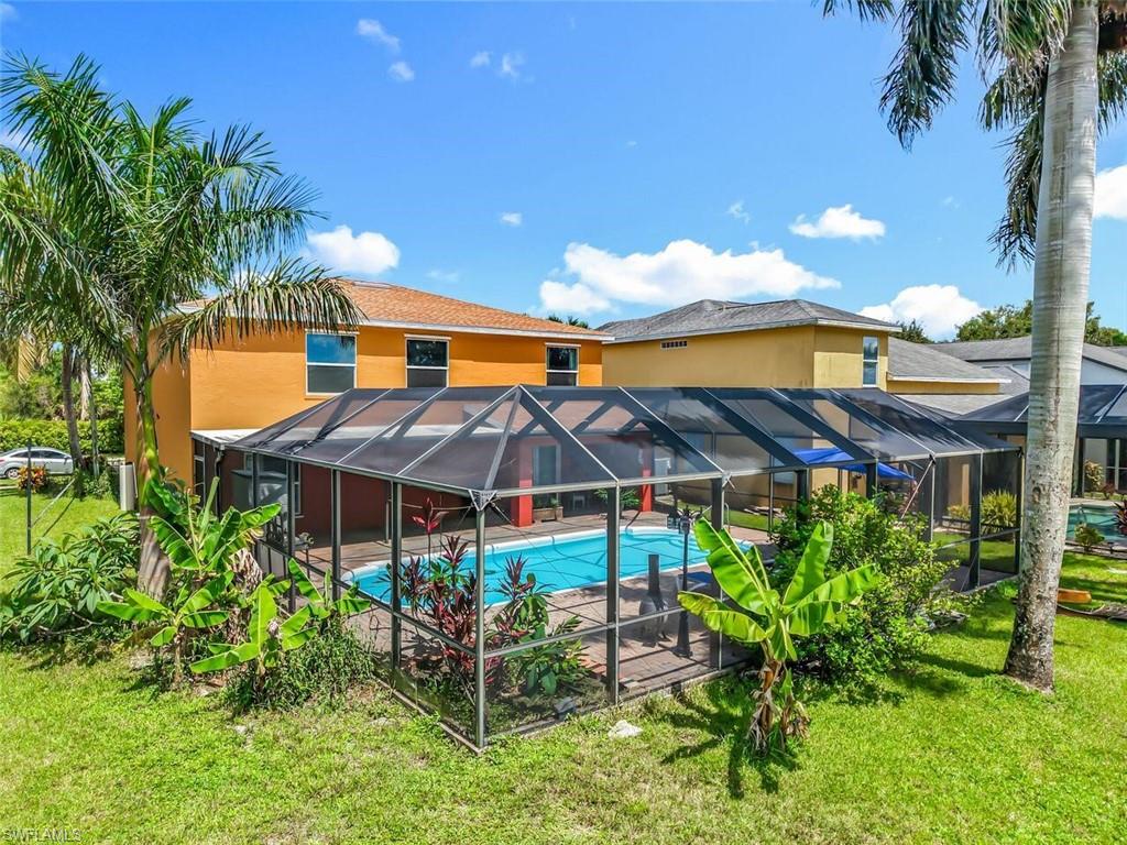 14991 Savannah Drive Naples, FL 34119 - Photo 49 of 50 a view of a house with a chairs and table under an umbrella