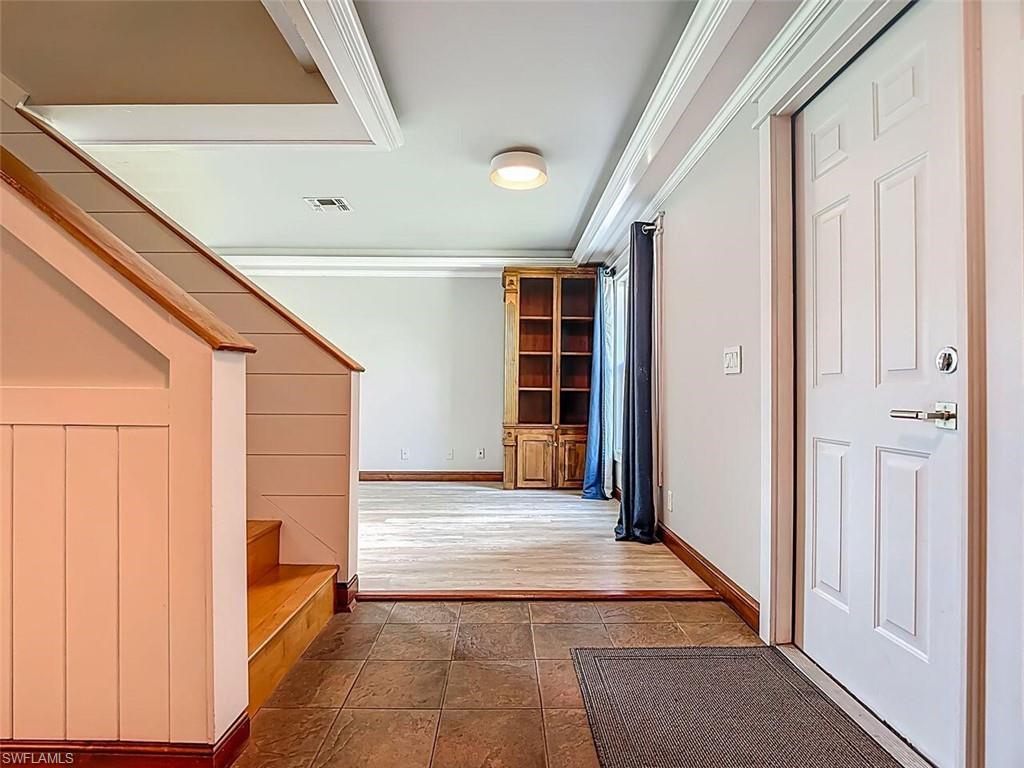 14991 Savannah Drive Naples, FL 34119 - Photo 9 of 50 a view of a hallway with wooden shelves and door