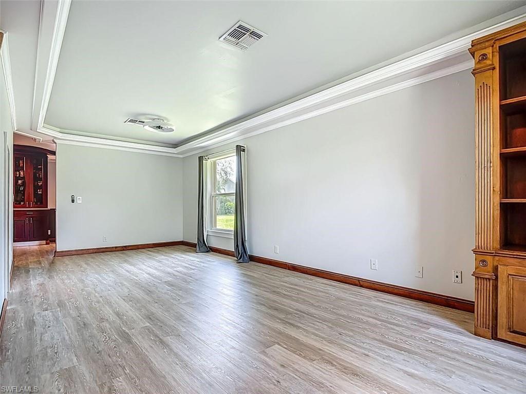 14991 Savannah Drive Naples, FL 34119 - Photo 10 of 50 an empty room with wooden floor and windows
