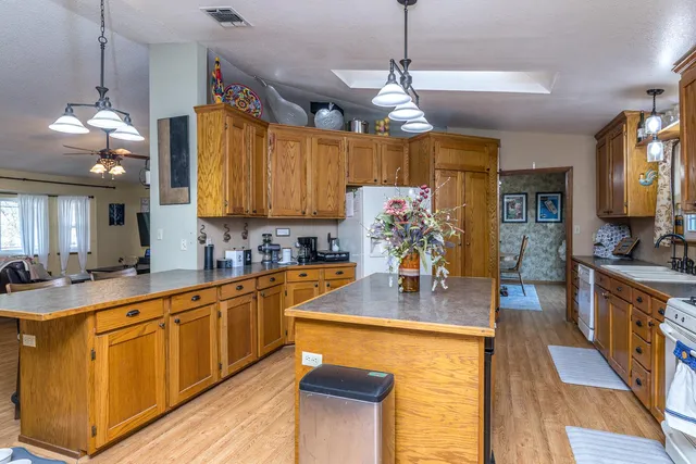 a kitchen with stainless steel appliances granite countertop a sink window and cabinets