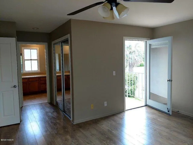 a view of a hallway with wooden floor and a living room