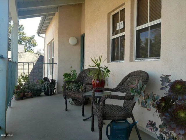 a balcony with potted plants and a bench