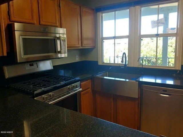 a kitchen with stainless steel appliances a stove microwave and cabinets