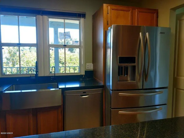 a kitchen with stainless steel appliances granite countertop a refrigerator and a sink