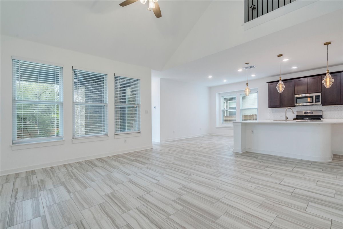 8008 Prairie Rye Drive Lago Vista, TX 78645 - Photo 5 of 40 Open-concept living space featuring high vaulted ceilings, light-tone wood-finish flooring, and a kitchen island with pendant lighting