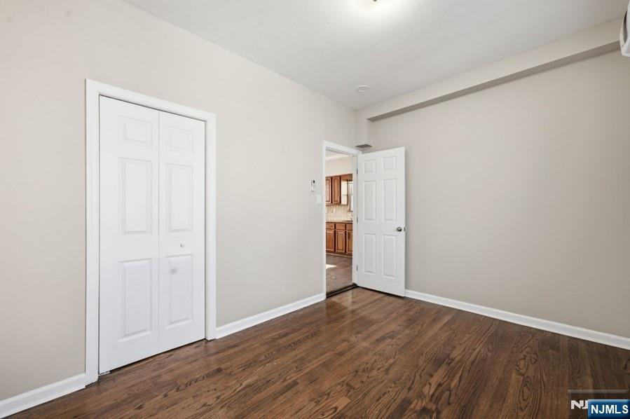 693 North 8th Street Newark, NJ 07107 - Photo 7 of 23 an empty room with wooden floor & closet and windows