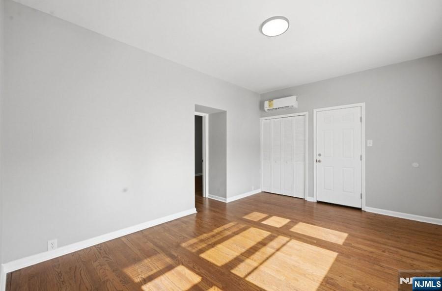 693 North 8th Street Newark, NJ 07107 - Photo 8 of 23 an empty room with wooden floor and windows