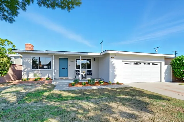 a view of a house with backyard and sitting area