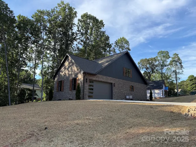 a view of a house with a yard and large trees
