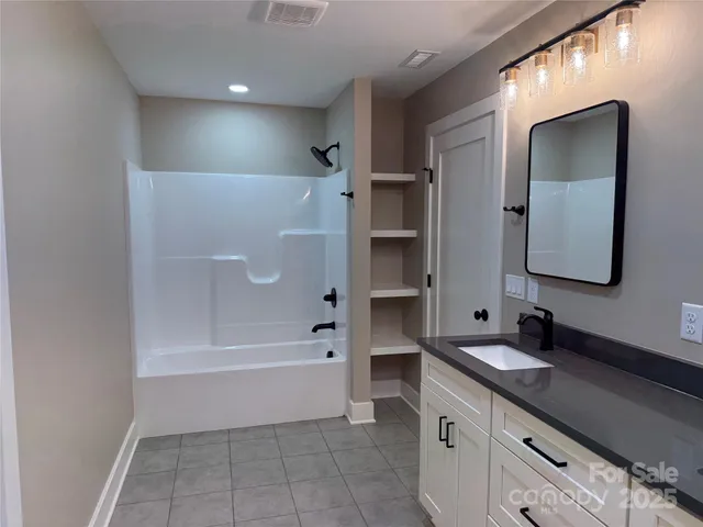 a bathroom with a bathtub a mirror a vanity and vanity