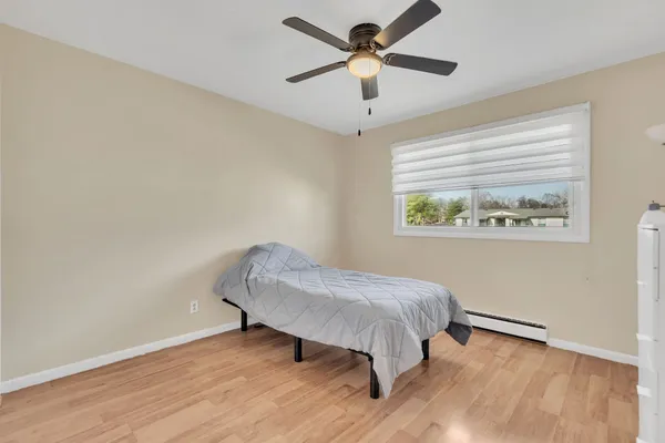 a bedroom with a bed and a chandelier fan