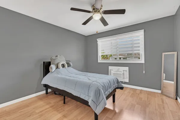 a bedroom with a bed and wooden floor