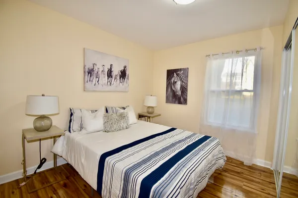 a bedroom with a bed and a painting on the wall