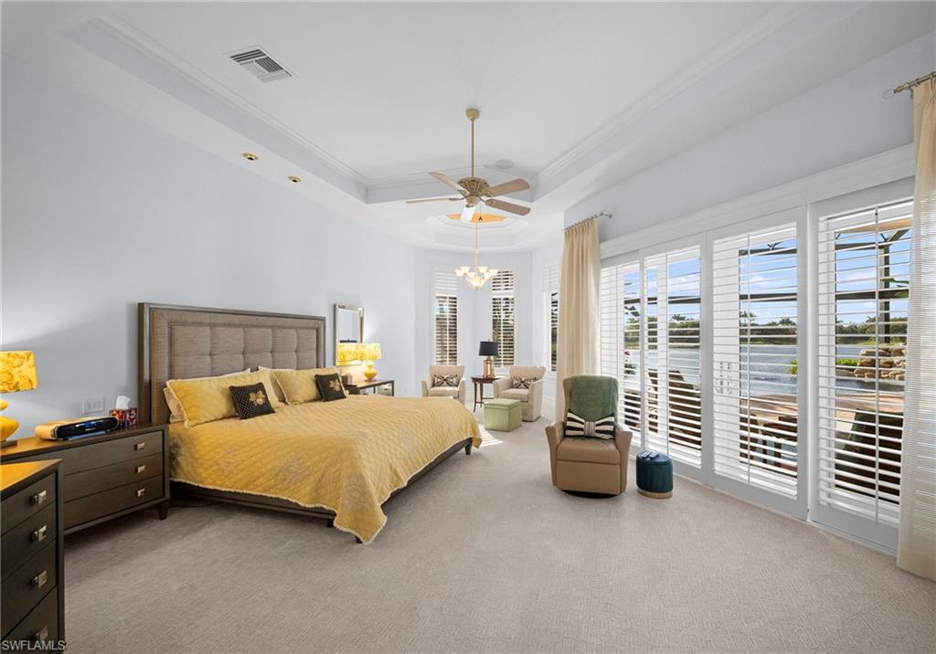 10057 Orchid Ridge Lane Estero, FL 34135 - Photo 15 of 30 a bedroom with a bed and a chandelier