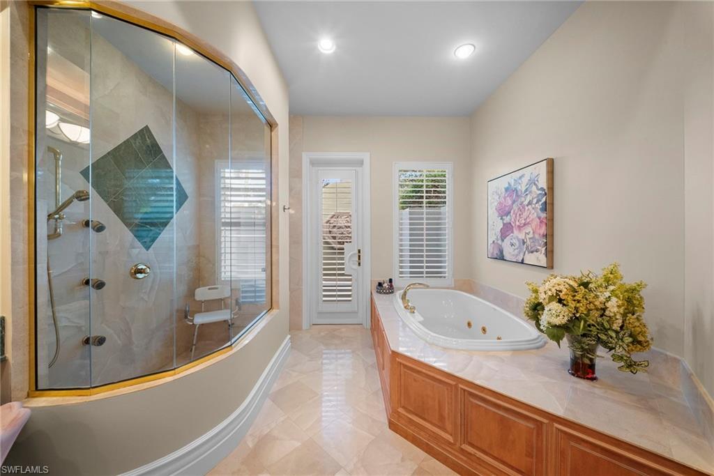 10057 Orchid Ridge Lane Estero, FL 34135 - Photo 23 of 30 a bathroom with a tub sink and mirror