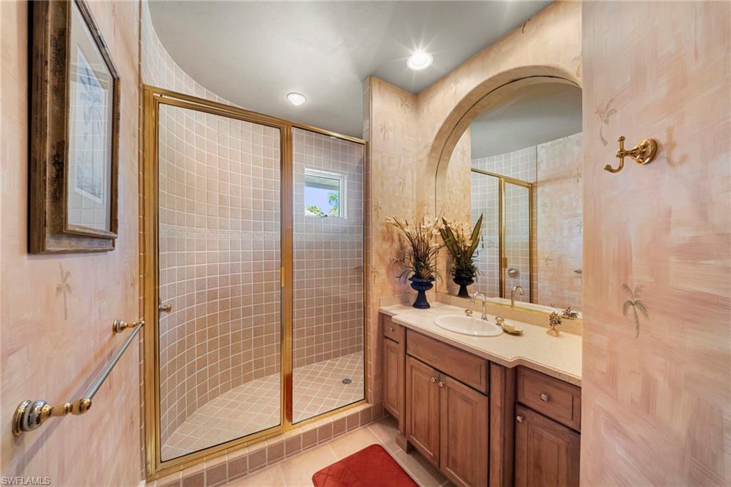 10057 Orchid Ridge Lane Estero, FL 34135 - Photo 27 of 30 a bathroom with a double vanity sink mirror and shower