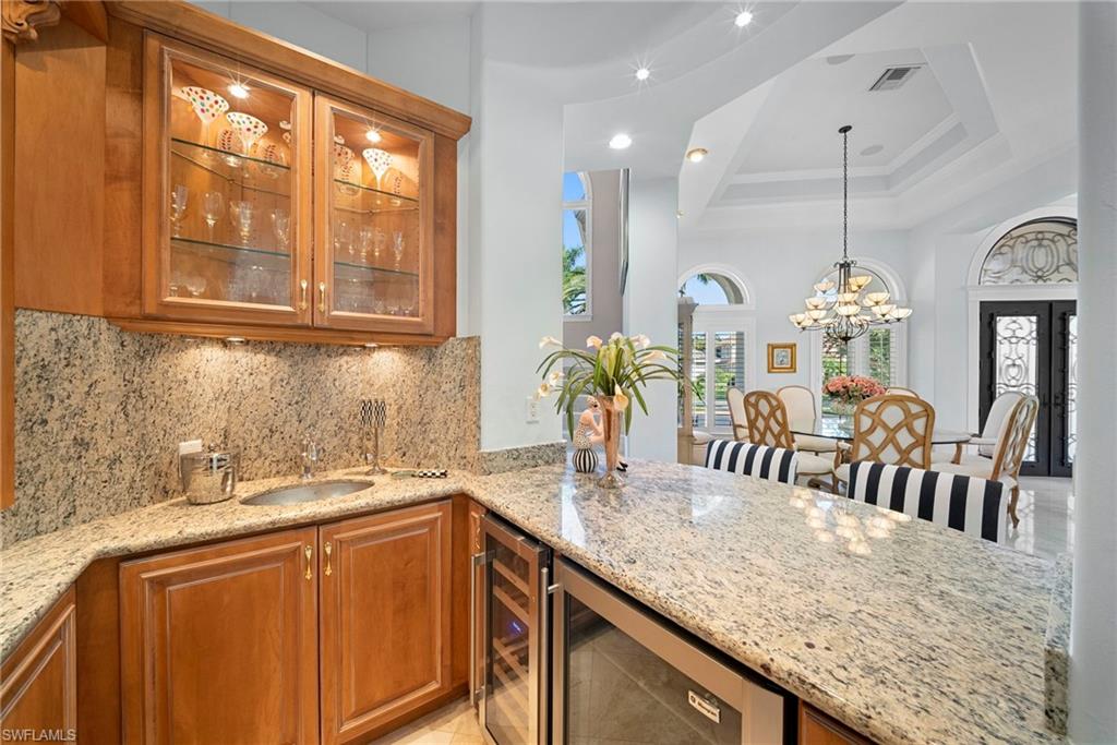 10057 Orchid Ridge Lane Estero, FL 34135 - Photo 6 of 30 a kitchen with granite countertop a sink stainless steel appliances and white cabinets