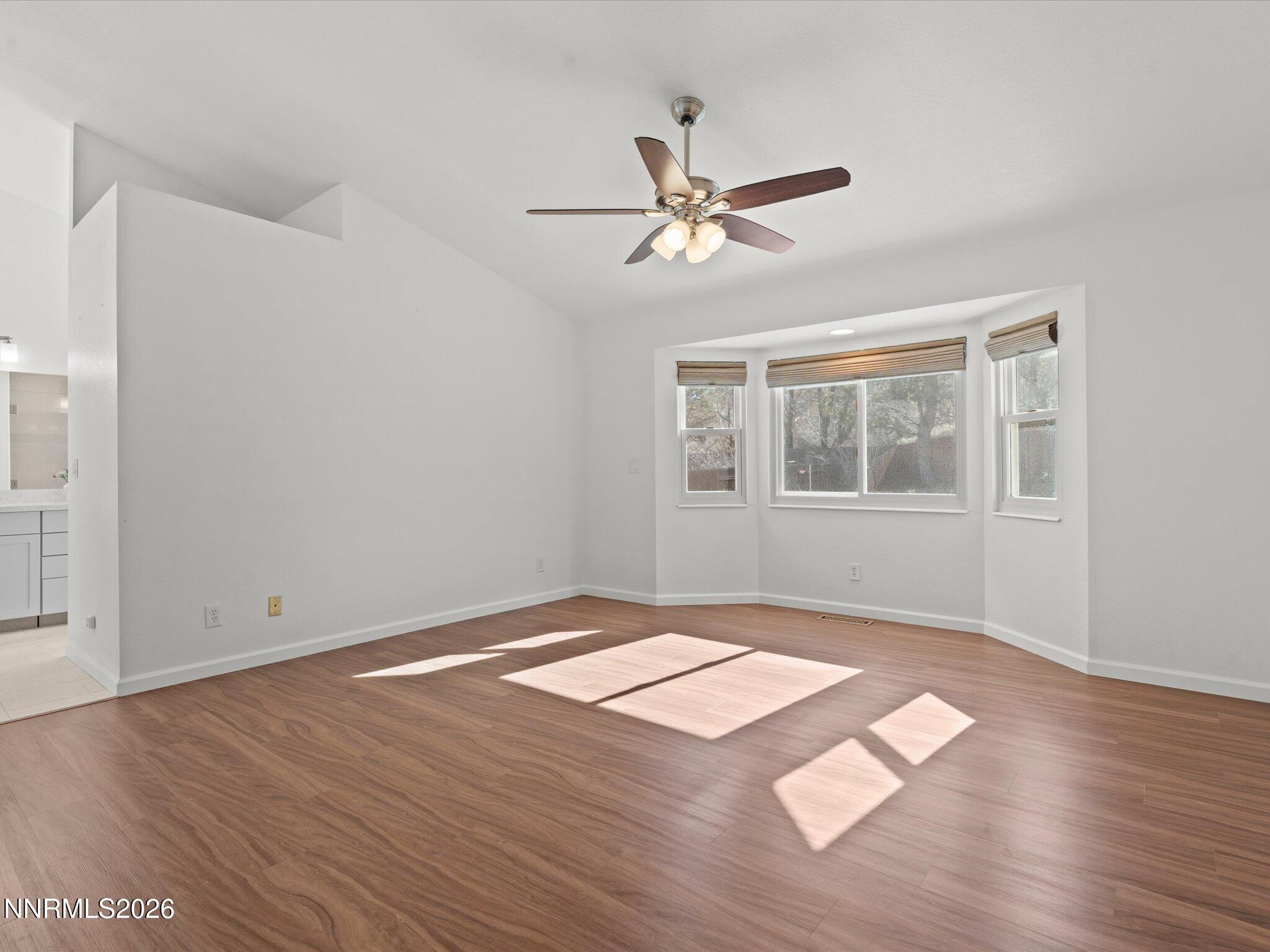1588 Wheatgrass Drive Reno, NV 89509 - Photo 26 of 42 a view of an empty room with wooden floor and a window