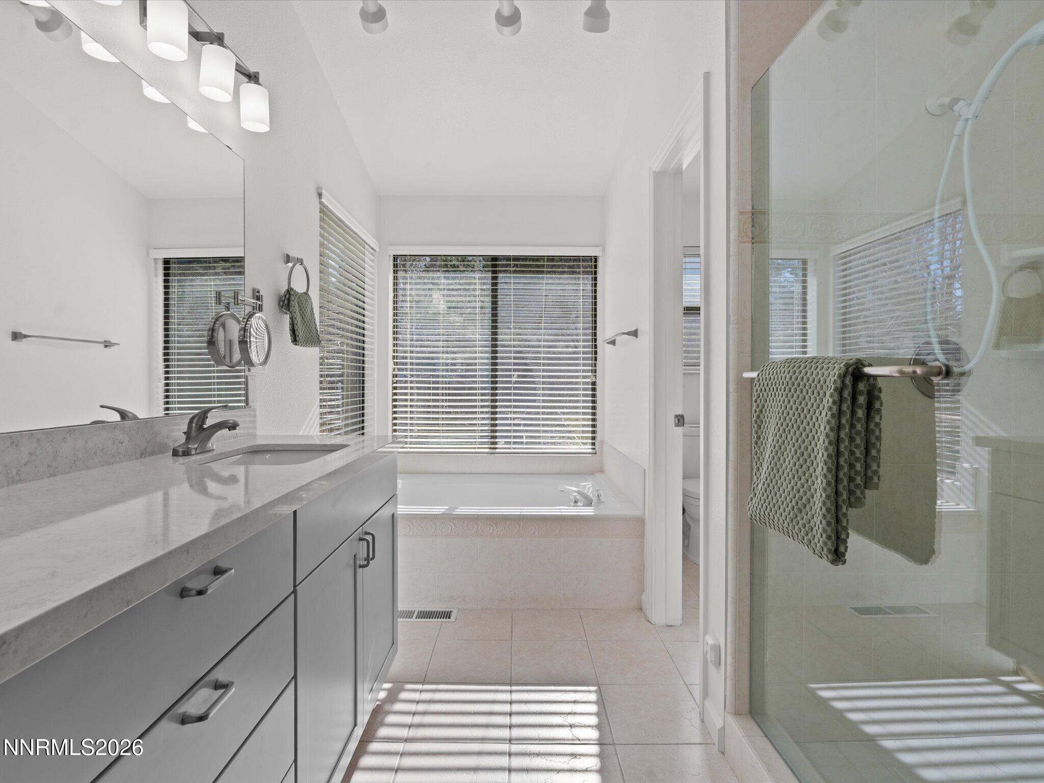 1588 Wheatgrass Drive Reno, NV 89509 - Photo 29 of 42 a bathroom with a double vanity sink a mirror a shower and a bathtub