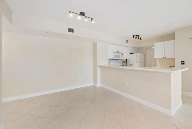a view of kitchen with refrigerator and window