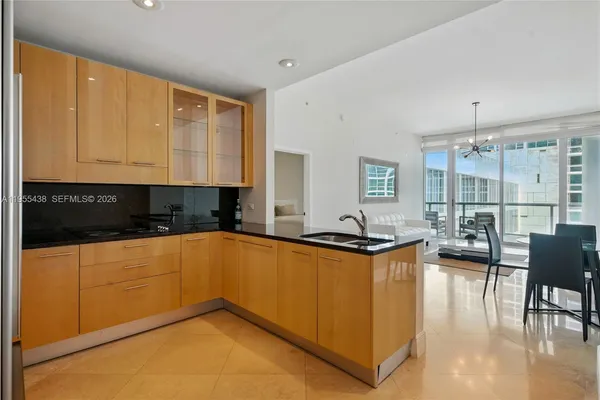 a kitchen with stainless steel appliances granite countertop a sink and a refrigerator
