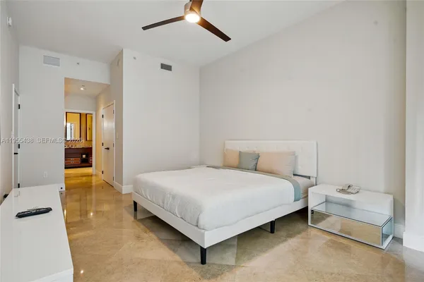 a bedroom with a bed and a flat tv screen on the dresser