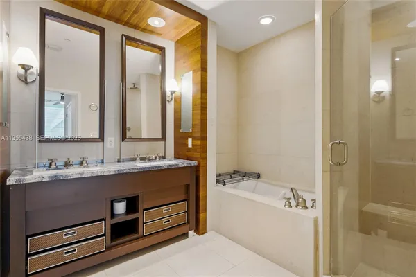 a bathroom with a granite countertop sink a mirror and a bathtub
